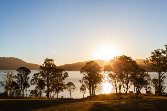 Cars parked at campsite alongside shore of inland water catchment lake