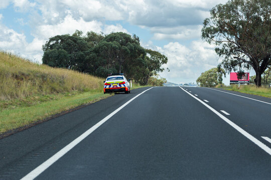 Police car pulled over beside road on highway at hilltop