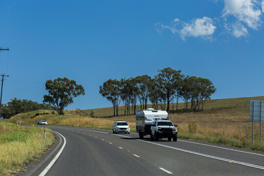 Car towing caravan along highway in Australia