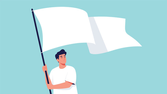 Young man holding and waving a large white flag representing peace or surrender against a clear blue background.