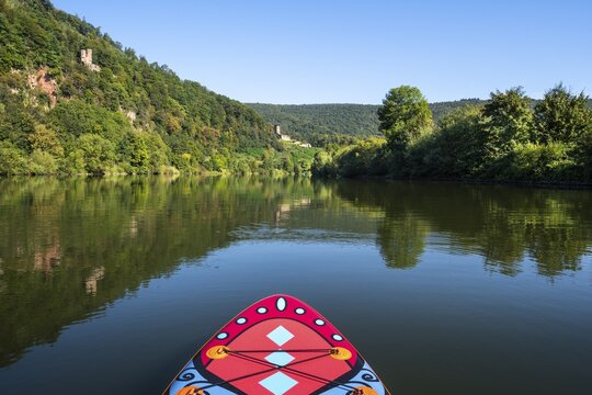 SUP board on the Neckar near Neckarsteinach. The Schwalbennest castle ruins at the top left, the Hinterburg ruins in the centre. Neckarsteinach, Odenwald, Rhine-Neckar district, Baden-W&uuml;rttemberg, Germany