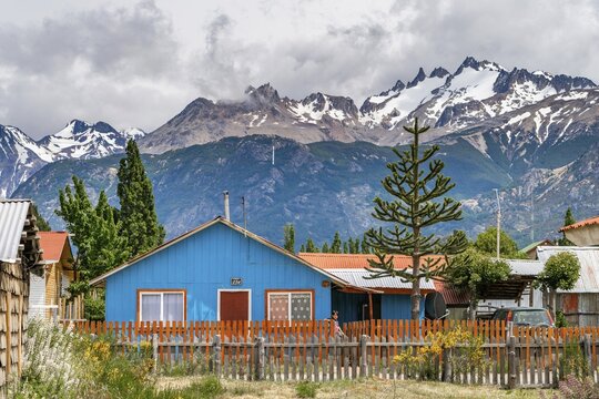 Blue wooden house, Cerro Castillo mountain range in the back, Villa Cerro Castillo village, Cerro Castillo National Park, Aysen, Patagonia, Chile