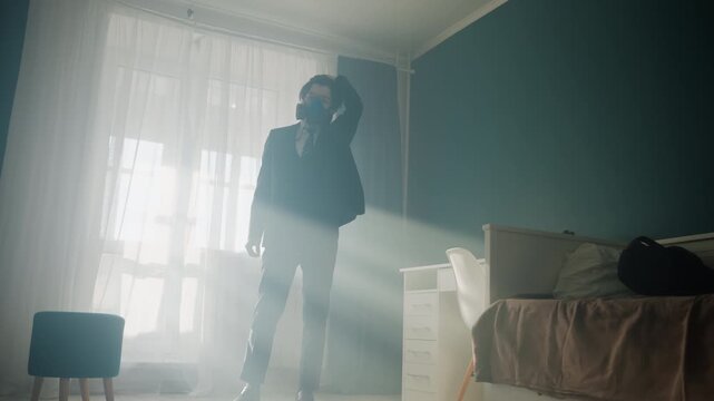 Backlit young man sits in bedroom, suit and hat, sunlight streams through sheer curtains, dusty rays create cinematic moody atmosphere, sequence shows sitter moving to window, pacing, thoughtful