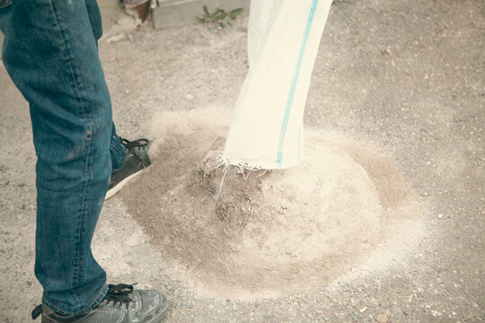 Worker spreading sand on the floor at construction site, retro toned
