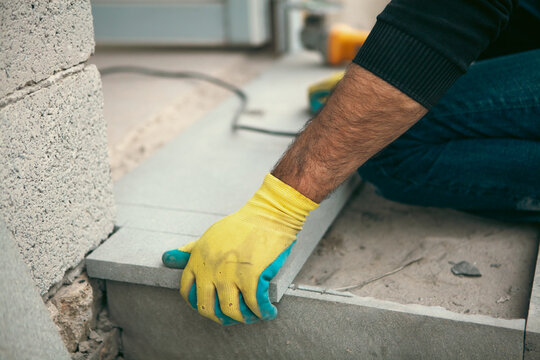 Worker installing aerated concrete slab at construction site, closeup