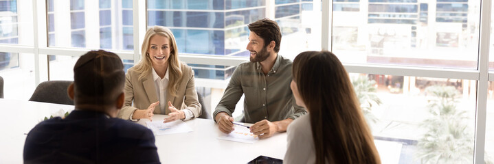 Group of diverse business team engaged in productive meeting in modern office, discussing documents...