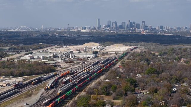 Aerial view of a freight train yard with the Dallas skyline