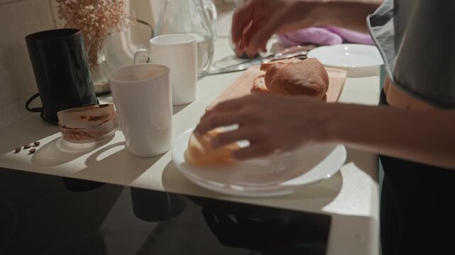 Sunlit kitchen counter caucasian woman preparing breakfast, music lover enjoying calm ritual, hands slicing wholegrain bread, cheese on white plate, ceramic mug, warm glow, dried flowers, cozy home
