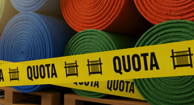Rolls of industrial fabric stacked on a pallet behind yellow quota tape. Textile manufacturing materials constrained by trade regulations. Global trade policy and supply chain limit concept.
