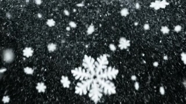 White snowflakes falling against a dark background during a winter storm
