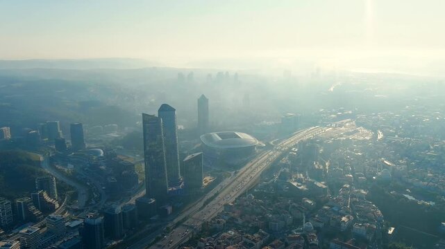 Istanbul, Turkey. Skyland Istanbul towers and Rams Park Stadium, Drone footage at summer morning backlight over the Huzur district, with highway traffic and hazy skyline. Drone footage