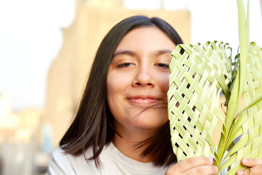Latin kid holding palm branch beautifully braided for Palm Sunday.