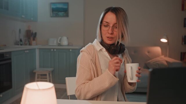 Woman enjoying music and coffee. Woman sipping coffee while listening to music in cozy home space. Female music lover taking peaceful pause with headphones and handwritten notes at home