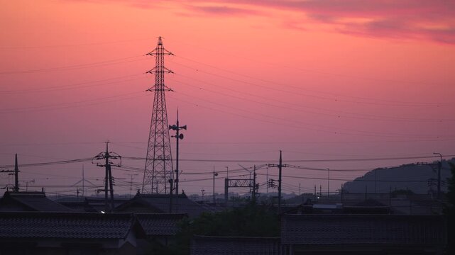 朝焼けでオレンジ色に染まる空と送電線の鉄塔_10bit_4:2:2_フィックス
