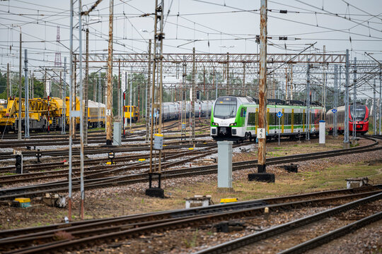 Warsaw, Poland - May 31, 2026: Train moving on multiple tracks near Warszawa Wschodnia railway station with maintenance trains and heavy infrastructure equipment in the background