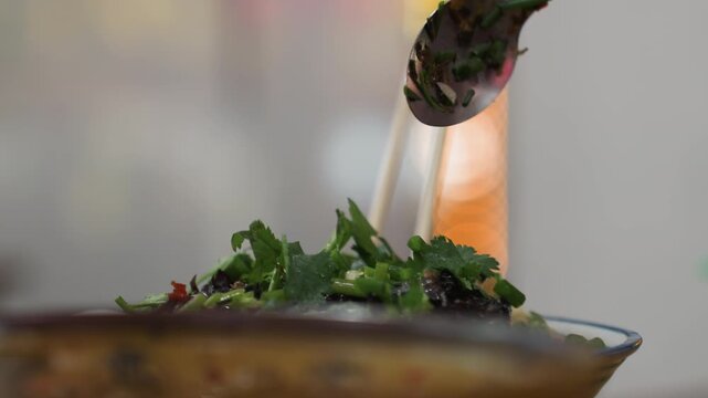 Closeup greens served at market stall, vendor spooning herbs over plate, warm neon bokeh in background, quick serving motion and drizzle of dressing, casual urban streetfood vibe and lively stall