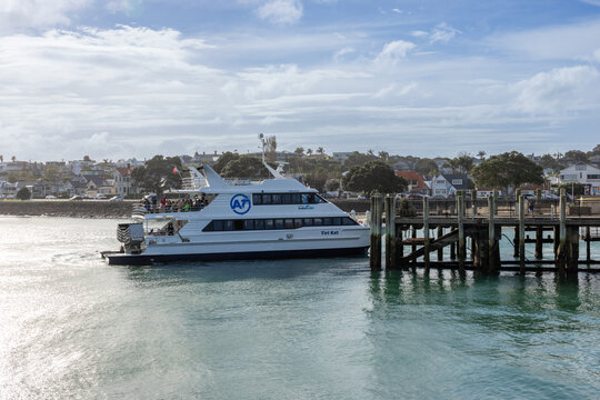 AUCKLAND, NEW ZEALAND, 31 May 2026: The ferry 'Tiri Kai' departs from a pier in Devonport, New Zealand, carrying passengers across the harbor on a cloudy day.