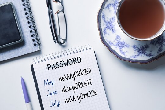 Reset password every month for the credentials online concept on notepad. Workplace with a cup of tea. Top view.