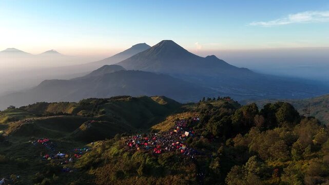 Aerial footage of the Prau mountain landscape in clear weather with a view of a group of climbers' tents.