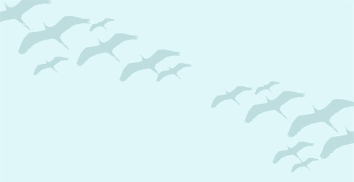 Silhouette of flock of birds flying in the blue sky background