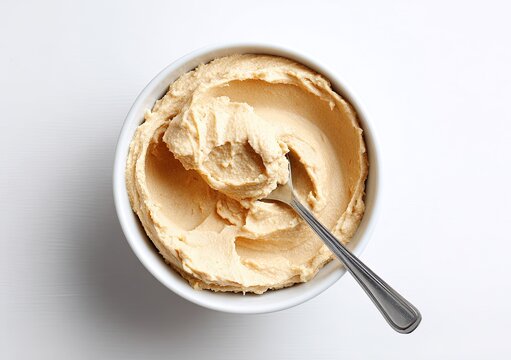 Creamy Hummus in a White Bowl with a Spoon Overhead View.