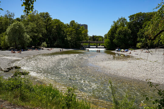 The Flaucher, a sprawling, unspoiled stretch of the Isar on a sunny summer day in Munich. The Flauchersteg in the background