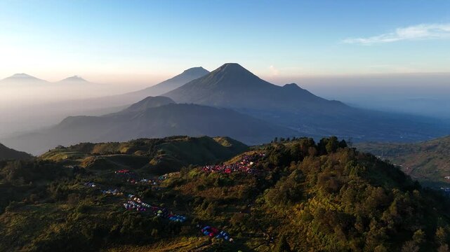 Aerial footage of the Prau mountain landscape in clear weather with a view of a group of climbers' tents.