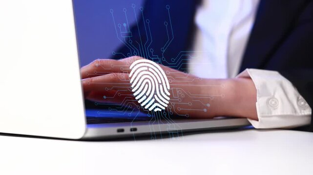 Close-up view of a hand using a laptop with a fingerprint icon on the screen during a work session focusing on security.