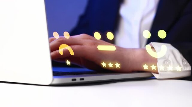 Person types on laptop with emoticons showing different expressions in an office setting during evening hours.