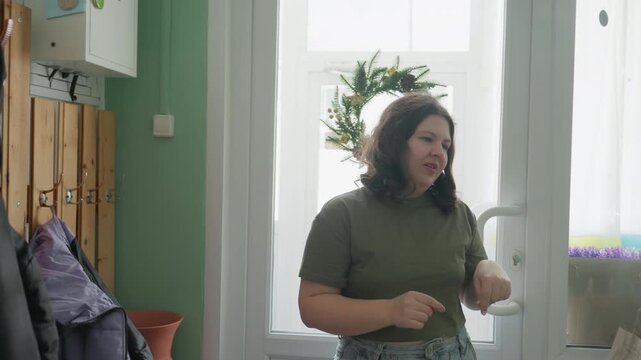 Pottery workshop assistant hangs coat, checks keyring and inspects order labels, packs paper bags and arranges display, quiet morning routine in cozy green studio with focused hands and friendly