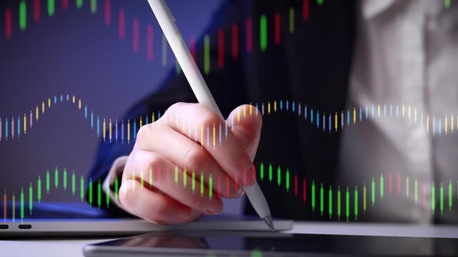 Person uses a digital pen on a tablet while analyzing data on a screen in an office setting during daytime.