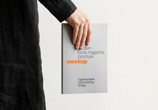 Hardcover Book Mockup Gripped From Top By Hand Side View On Light Background