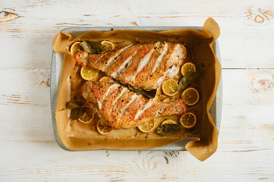 Red snapper baked with lemon and herbs on a baking tray ready for serving