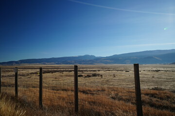 Obraz premium Scenic Wyoming and Montana Road Trip View with Fence and Mountains