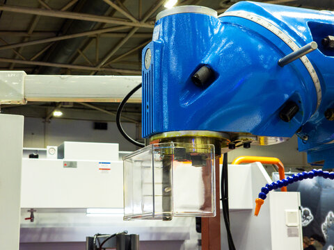 Industrial Blue Milling Machine Head with Safety Guard in Factory Setting