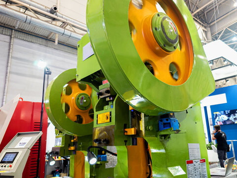 Large Industrial Power Press Machine with Rotating Flywheels in Modern Factory Workshop or Exhibition