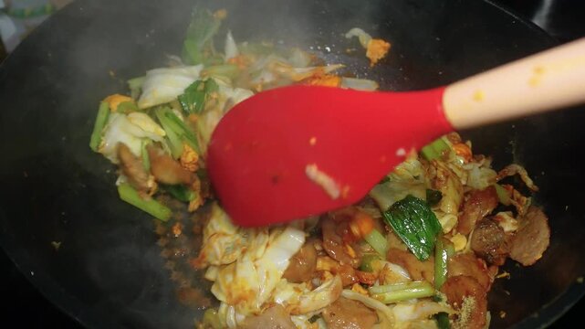 The process of cooking homemade stir-fried vegetables consists of eggs, cabbage, bok choy, sliced meatball, and bean sprouts
