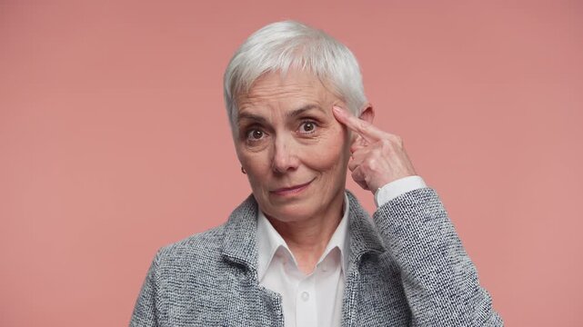 Senior woman gesturing sanity check on pink background