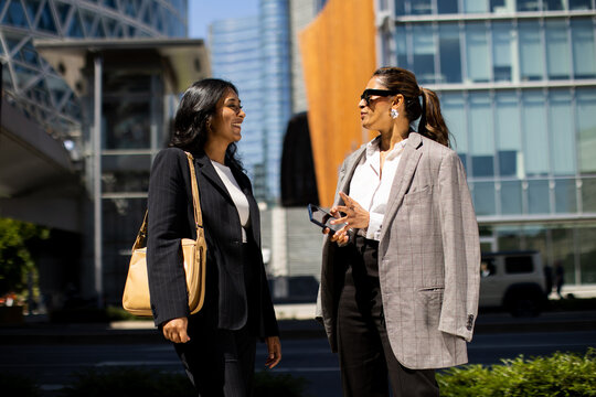 Friends enjoying conversation in a vibrant city street during daytime
