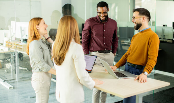 Team members share ideas and laugh together in modern office setting during the day