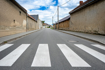 Empty village street with pedestrian crossing and old rural houses prazdna ulice ve vesnici obec Blatec, Czech Republic - May 10, 2026 © Professional Art