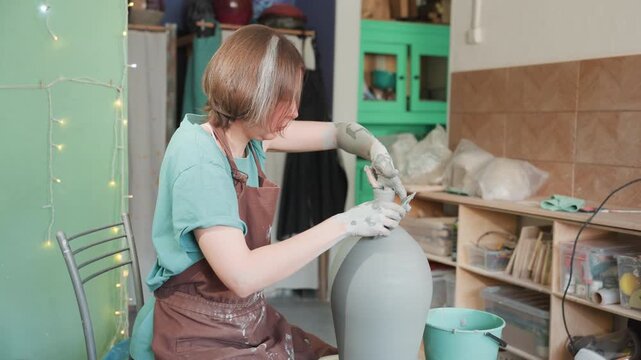 Caucasian ceramicist refining tall vase with careful trimming and smoothing, closeup hands shaping neck, mint studio backdrop and organized shelves, meditative creative session, soft natural light