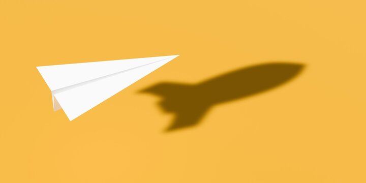 White paper plane with rocket shadow on yellow background, vision, growth or challenge business concept