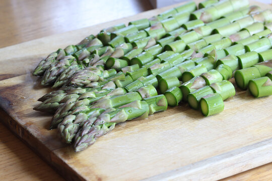 Chopped green asparagus on a kitchen board, preparing an asparagus dish.