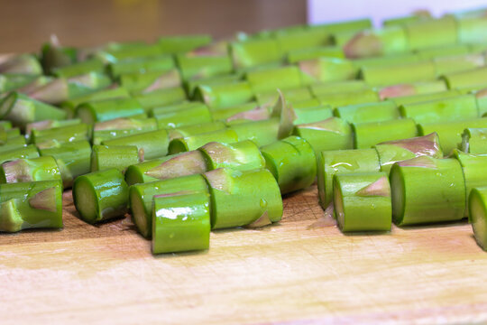 Chopped green asparagus on a kitchen board, preparing an asparagus dish.