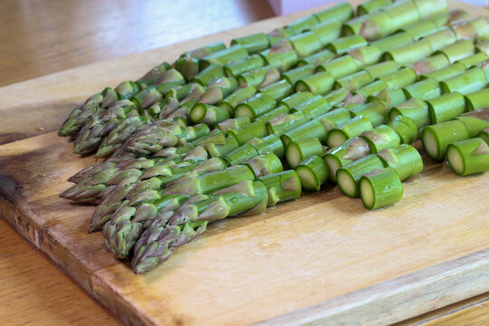 Chopped green asparagus on a kitchen board, preparing an asparagus dish.