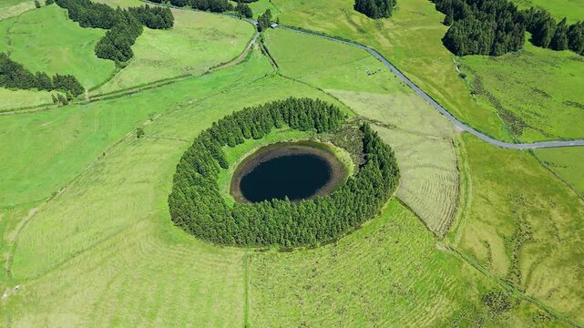 Drone view over round Pau Pique lake surrounded in beautiful green landscape on Sao Miguel Island, Portuguese Azores