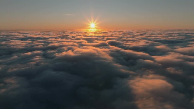 Serene aerial perspective looking out over an endless, textured sea of clouds at sunset, with the sun creating a brilliant starburst effect and a warm, golden glow across the horizon.