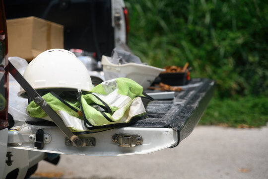 White Hard Hat and Safety Vest on Pickup Truck Tailgate at Construction Worksite