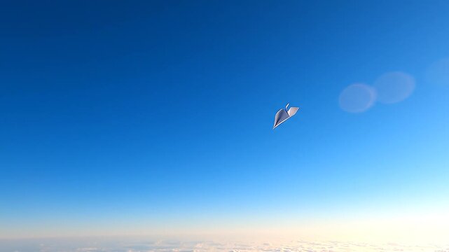 White paper plane flying and soaring high in negative space bright blue sky above clouds freedom dream imagination cinematic concept.